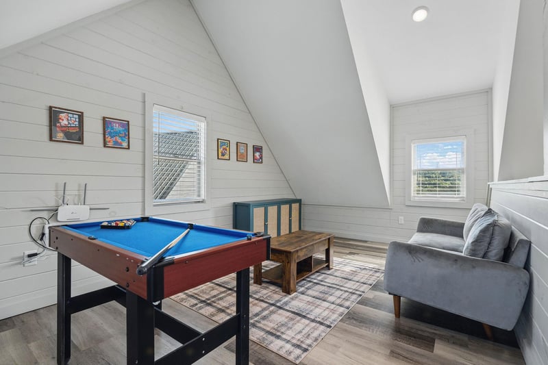 small pool table and sitting area with natural lighting