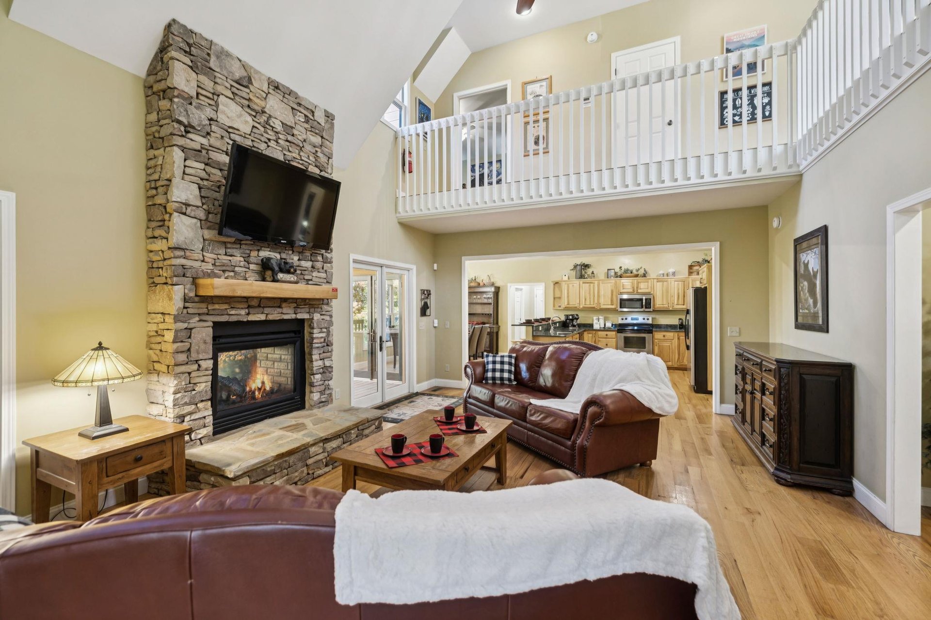 Unwind in your spacious living area with soaring ceilings, a cozy stone fireplace, and plush leather seating that invites you to relax after a day of adventure.