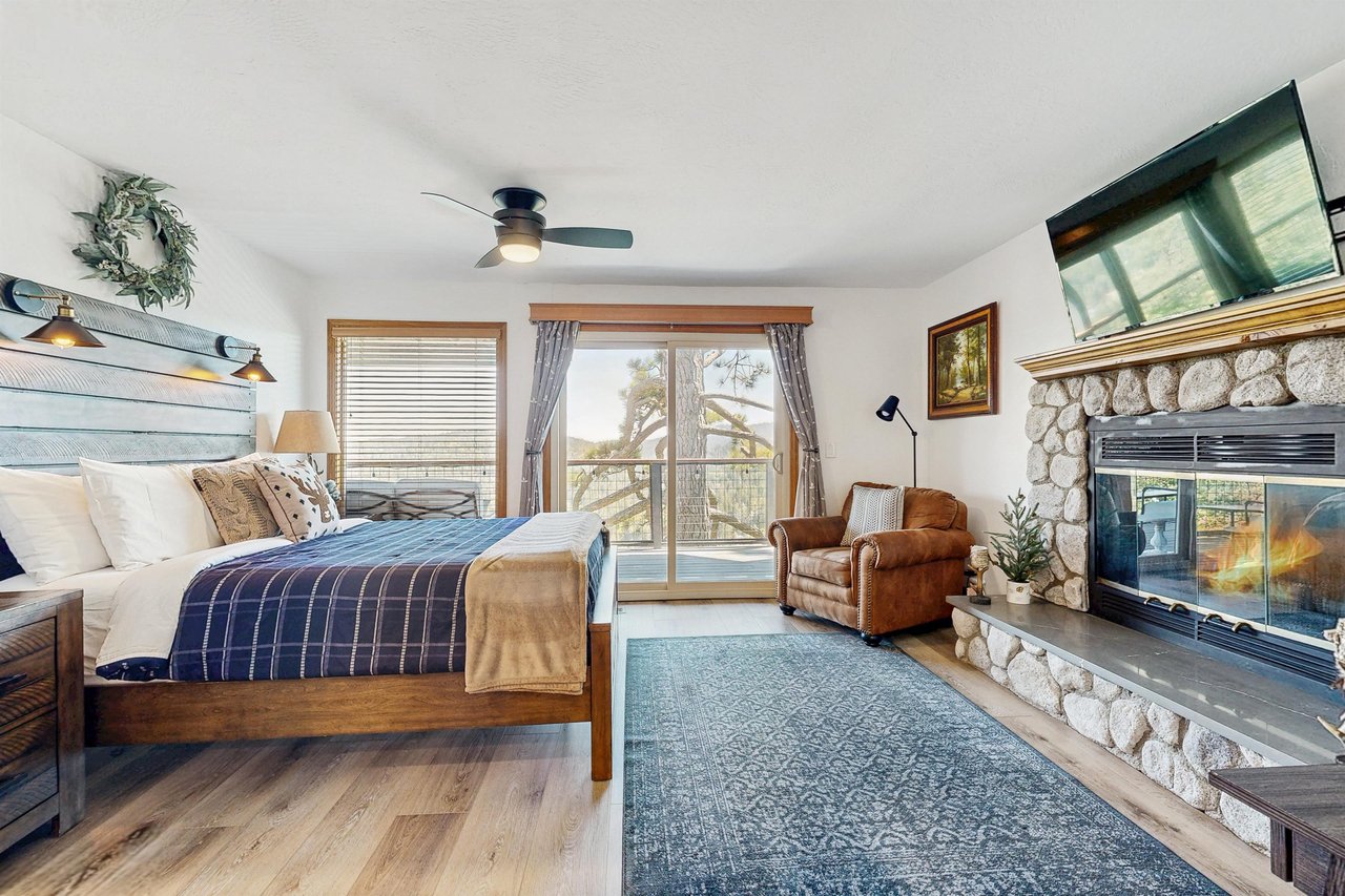 Features a king bed, fireplace, smart TV, deck access, and ensuite bathroom.