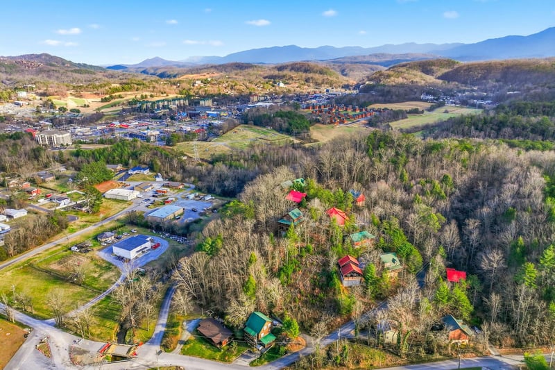 Aerial view of a peaceful mountain valley community with rolling hills and scenic countryside surroundings.
