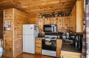 Your fullyequipped cabin kitchen features everything needed for memorable meals, from morning coffee to hearty dinners in rustic wood comfort.
