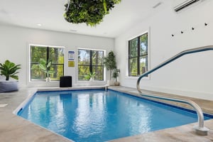 Your private indoor pool awaits, framed by windows overlooking lush greenery. Dive in anytime, surrounded by bright, airy spaces and tranquil plantfilled vibes.