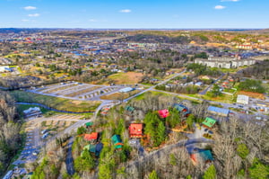 Aerial view of vacation rental cabins nestled among trees in a scenic mountain community setting.