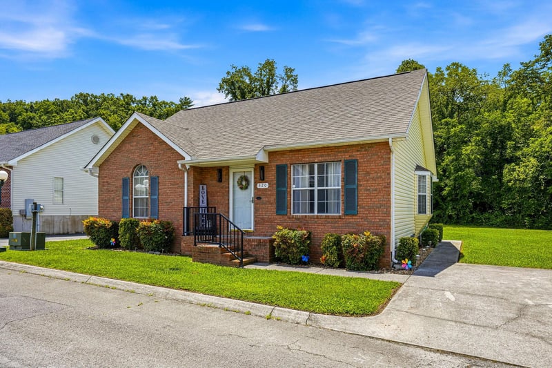 Charming brick property nestled in a quiet neighborhood surrounded by lush trees, offering a welcoming retreat for guests.
