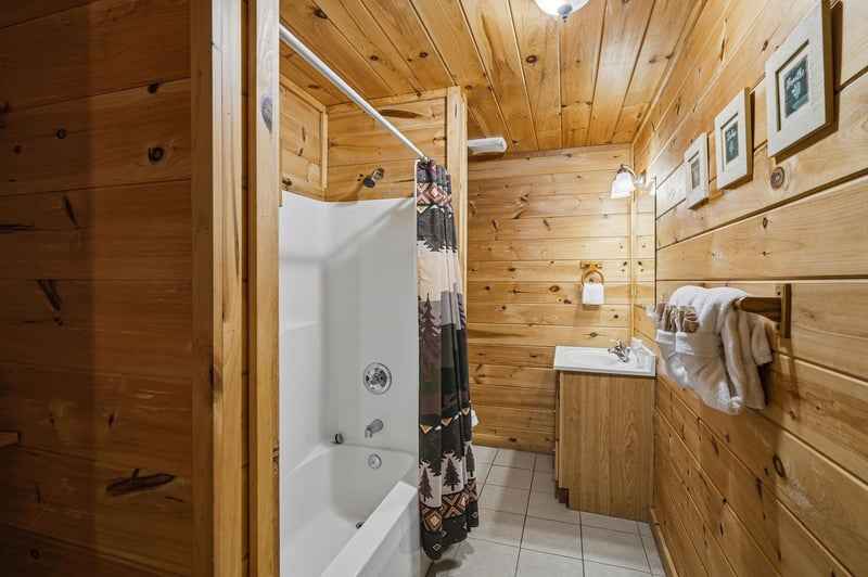 Unwind in your rustic bathroom where warm wood surrounds you, soft towels await, and a relaxing soak feels like pure mountain retreat magic.
