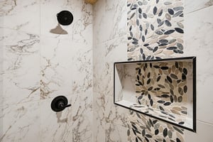 Elegant marble and mosaic tile create a spalike shower retreat, where each wash feels like a refreshing escape.