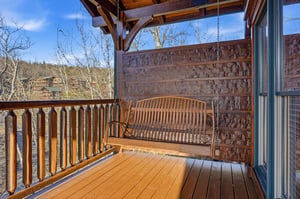 Sway gently on your private porch swing as you take in peaceful mountain views and listen to the rustle of bare branches under a clear blue sky—a perfect spot for morning coffee or evening reflection.
