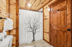 Refresh in your cozy cabin bathroom featuring warm wood paneling, fluffy towels, and natureinspired details.