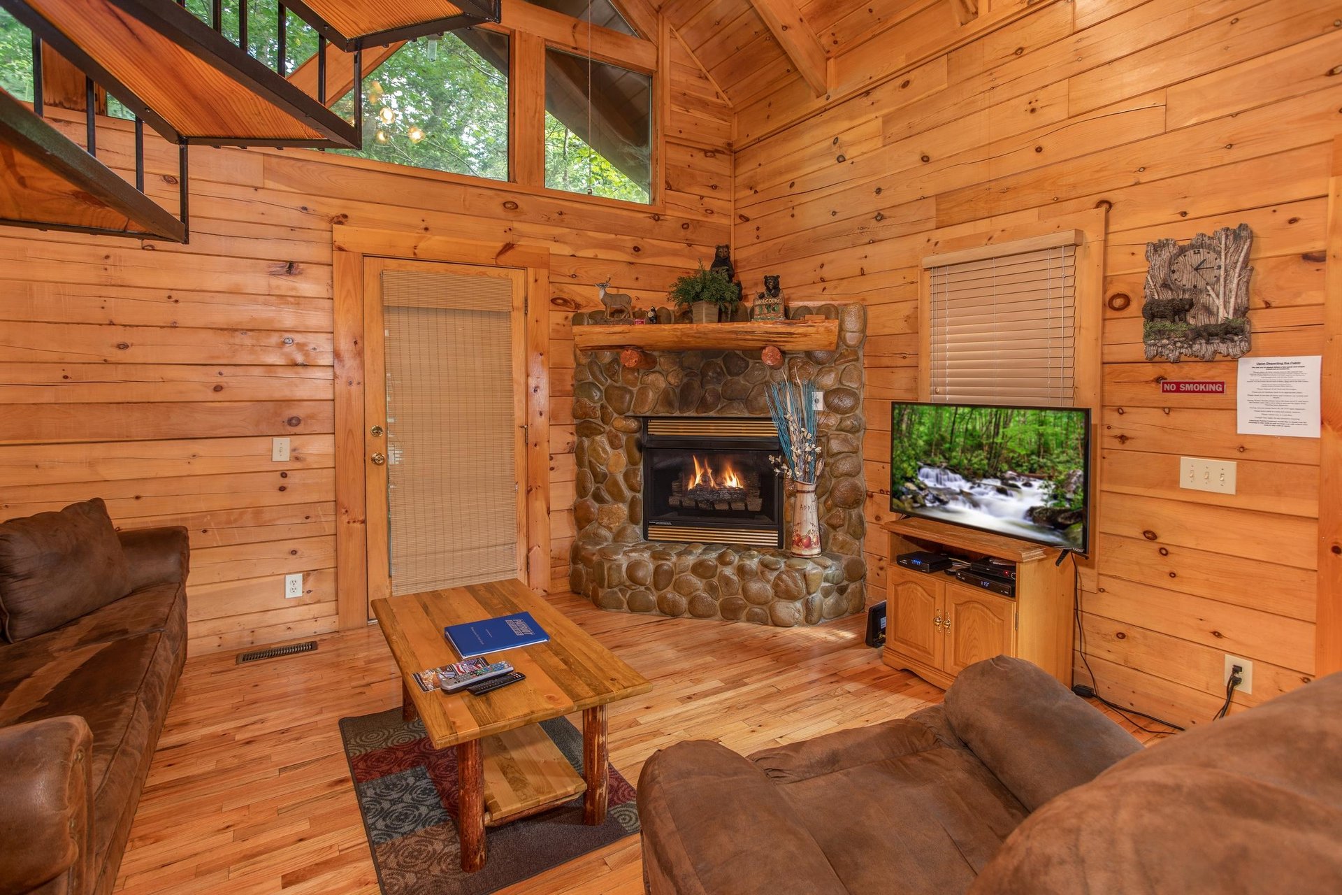Living room with a fireplace, television, and vaulted ceiling at Dreams Do Come True, a 1bedroom cabin rental located in Pigeon Forge