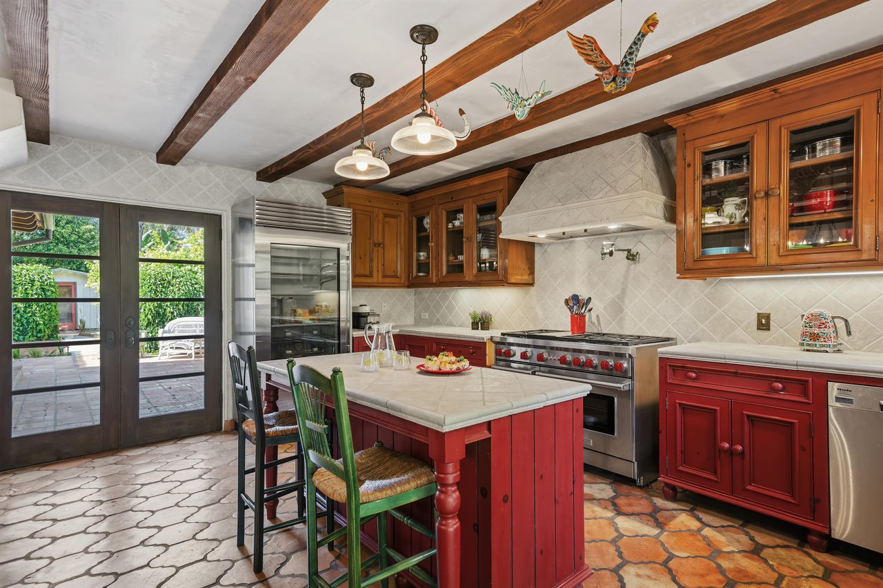 Spacious kitchen with stainless steel appliances, island with seating for 2, and cooking essentials.