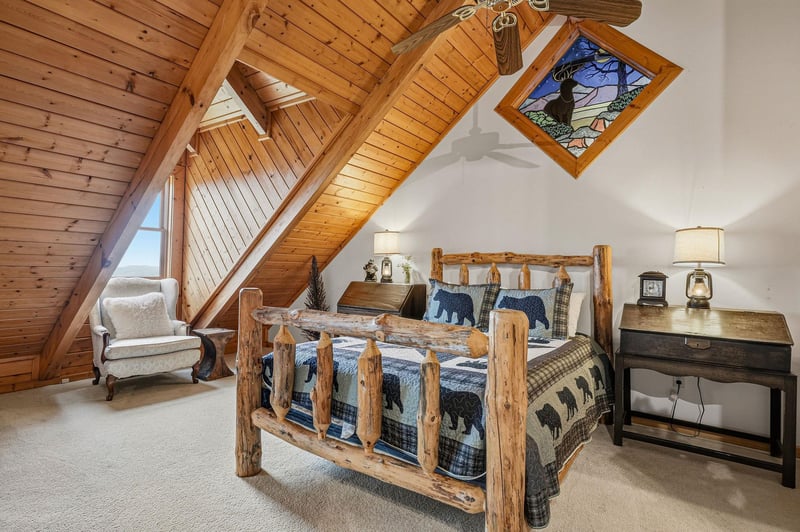 Cozy up in this charming log bed surrounded by warm wood beams and rustic mountain decor that makes bedtime feel like a retreat.