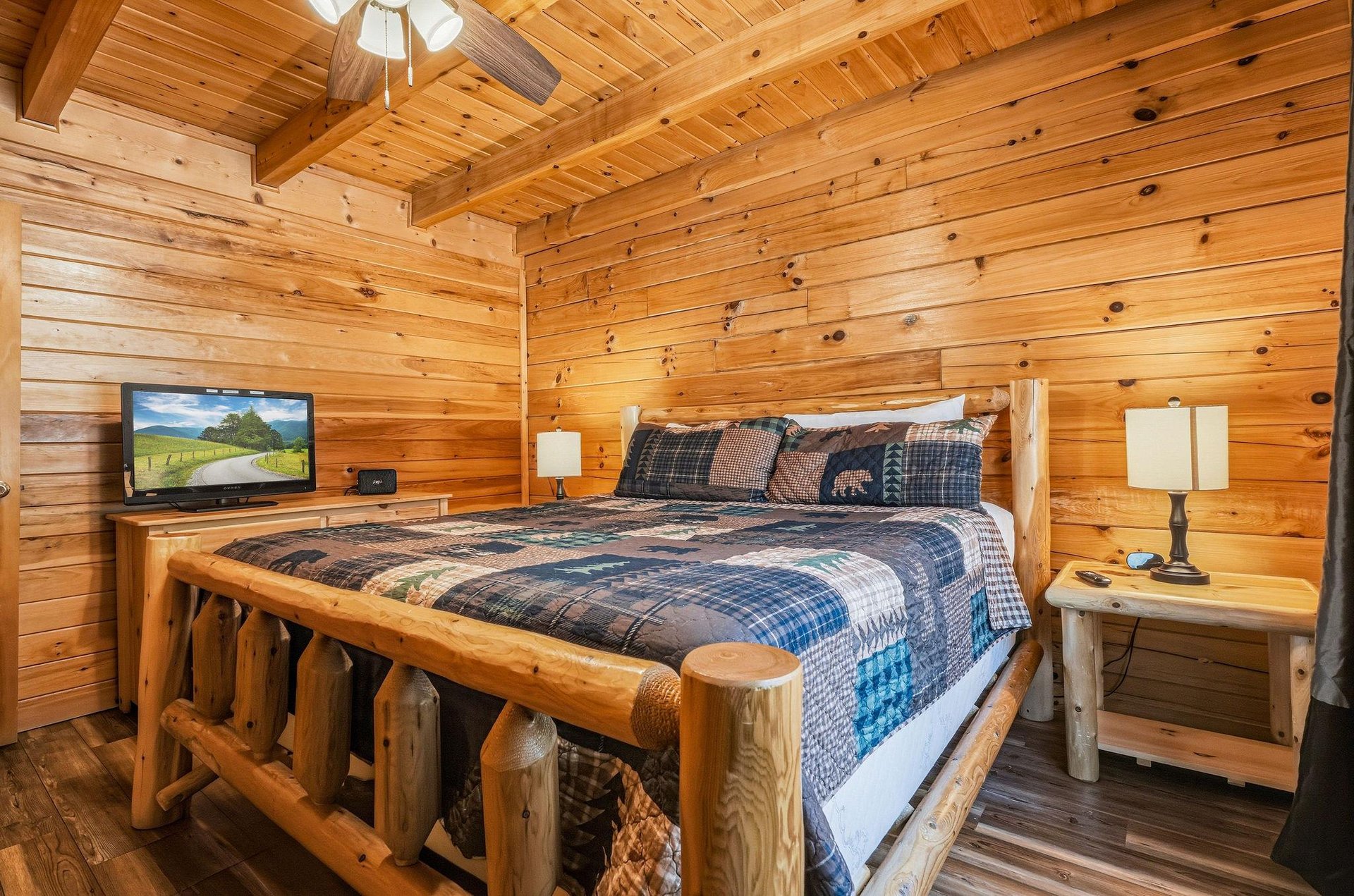 Slip into this handcrafted log bed and let the warmth of natural wood surroundings embrace you after a day of adventure. Your cozy cabin retreat includes a TV for unwinding and rustic charm in every d