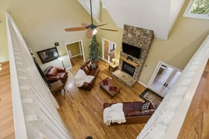 Soaring ceilings and rich hardwood floors frame your cozy living space, with a stone fireplace as the perfect gathering spot after a day of adventure.