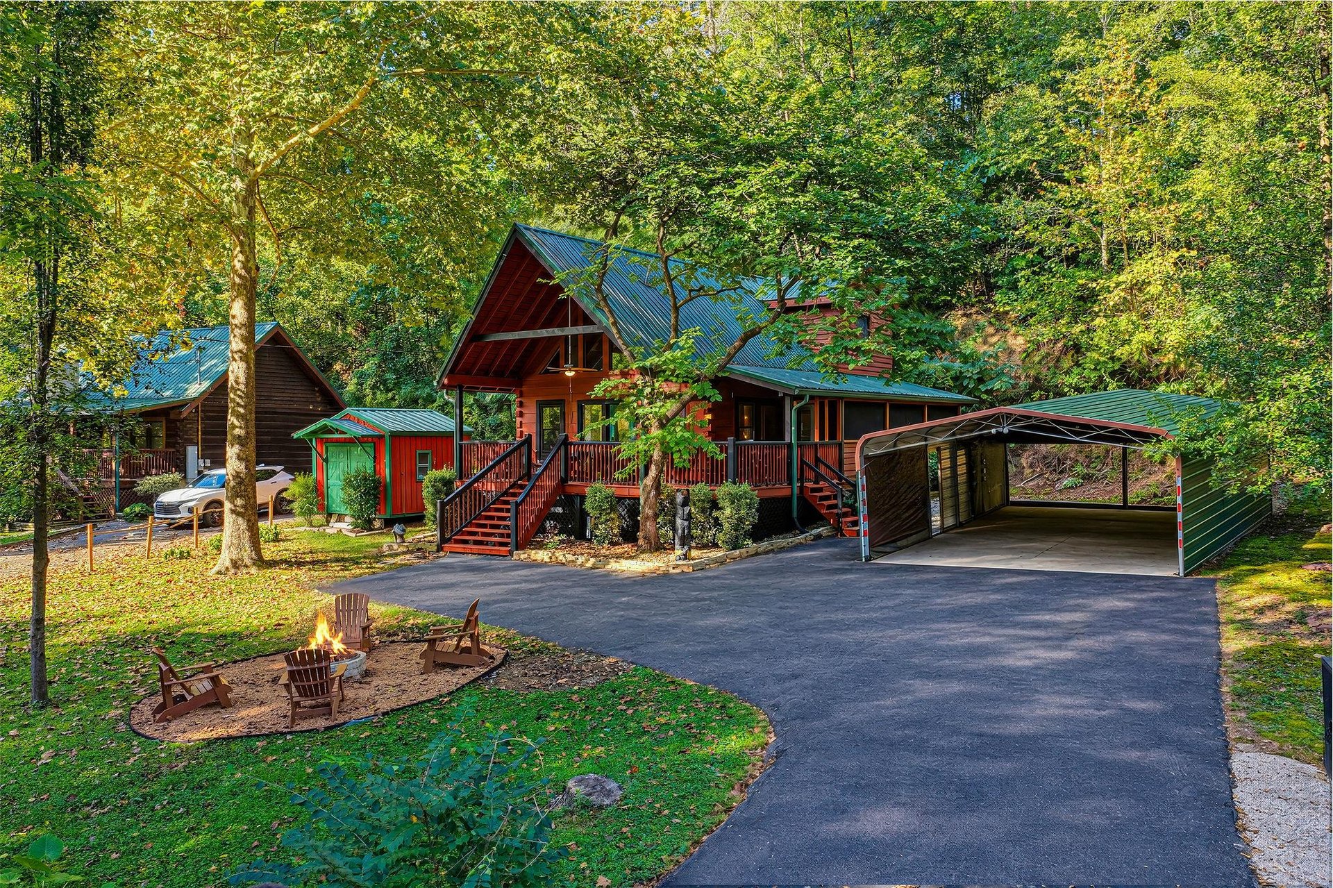 A charming cabin nestled among lush trees with covered parking and a welcoming fire pit for evening relaxation—your woodland retreat awaits.