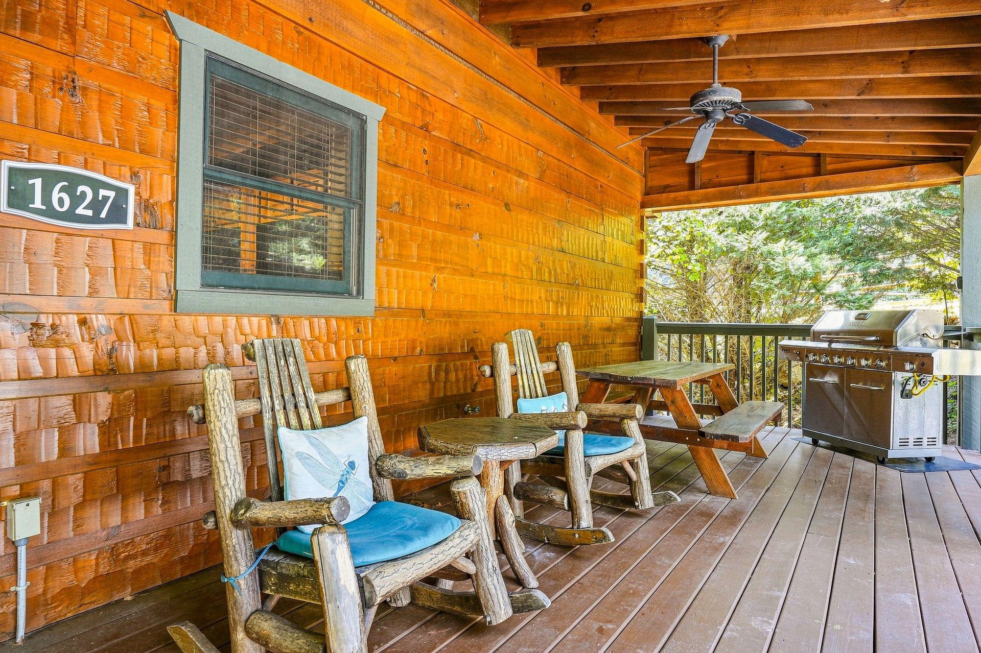 A shaded outdoor deck invites you to relax in handcrafted log furniture while enjoying the surrounding greenery. Fire up the gas grill for an effortless cookout under the ceiling fans gentle breeze.