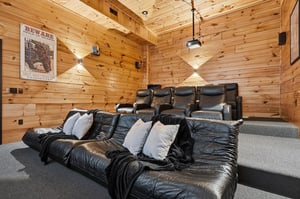 Sink into plush leather recliners in your private home theater, where warm wood walls create the perfect cozy escape for movie nights with your favorite people.