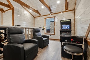 Unwind in your private game room with plush leather recliners and classic arcade entertainment for endless fun.