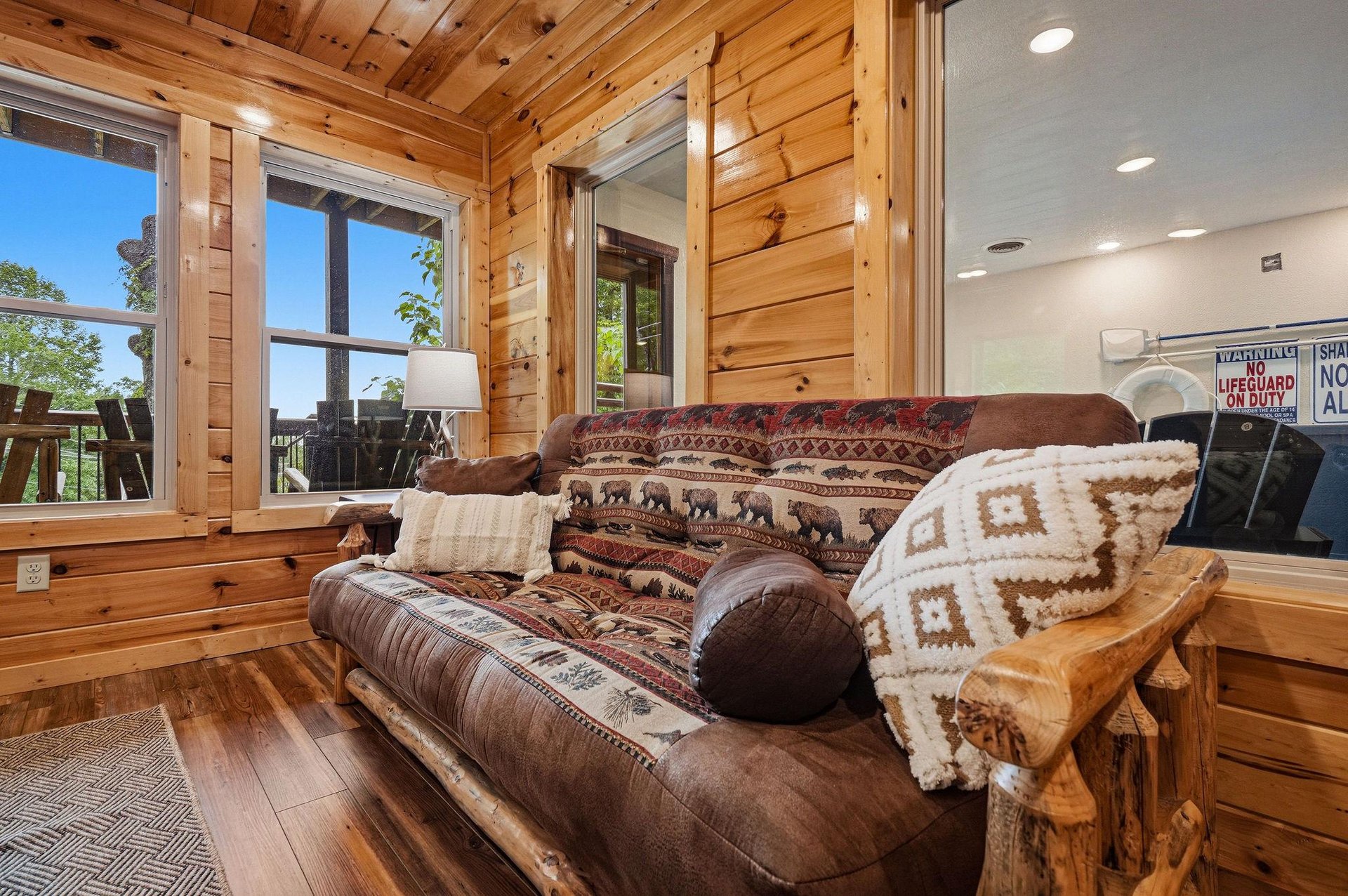 Sink into rustic comfort on your cozy sofa, wrapped in soft blankets while sunlight streams through the windows and illuminates warm wood details all around you.