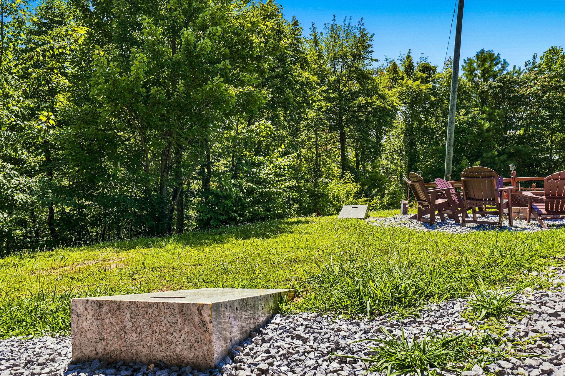 The property sits within a verdant natural setting with mature trees providing scenic surroundings and outdoor seating areas to enjoy the tranquil environment.