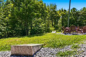 The property sits within a verdant natural setting with mature trees providing scenic surroundings and outdoor seating areas to enjoy the tranquil environment.