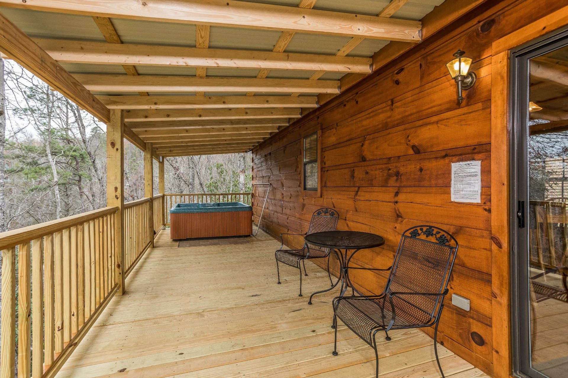 Bistro set for two and a hot tub on a covered deck at Boogie Bear, a 1bedroom cabin rental located in Gatlinburg