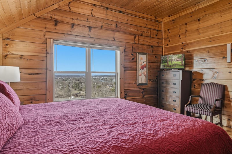 Drift off to sleep in your cozy log cabin bedroom, where warm wood surrounds you and panoramic valley views await through your bedside window.