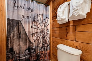 A charming rustic bathroom with warm wood walls, fresh white towels, and thoughtful touches that make you feel right at home.