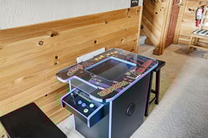 Challenge friends to classic arcade games on this retro cocktail table machine in your cozy cabin retreat.