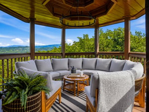 Imagine mornings with coffee here—soft cushions cradle you as rolling mountains stretch to the horizon. The gazebos warmth and mountain breezes create your perfect retreat.