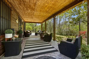 Unwind in your private covered patio, where comfortable wicker seating invites you to relax surrounded by lush garden views.