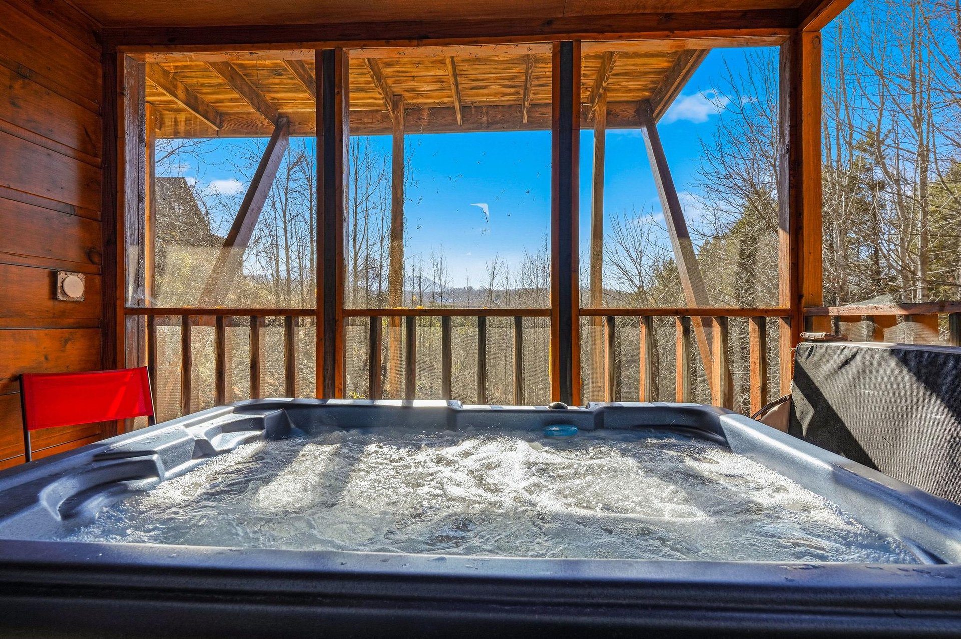 Soak in bubbling bliss as your private hot tub awaits on the covered deck, framed by forest views and endless sky.