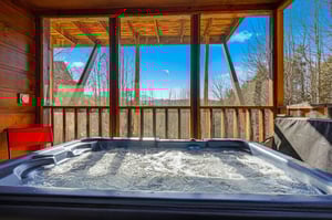 Soak in bubbling bliss as your private hot tub awaits on the covered deck, framed by forest views and endless sky.