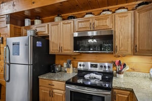 Step into your fullyequipped kitchen, where warm wood cabinets and modern stainless steel appliances make preparing meals a breeze. Everything you need is right at your fingertips in this cozy, rusti