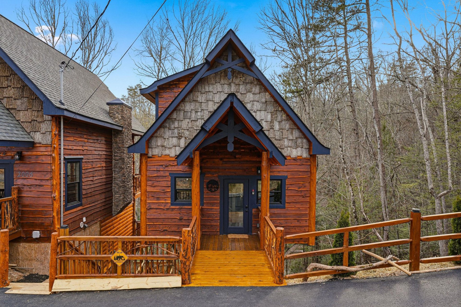 Charming log cabin with rustic wood siding and welcoming front porch, surrounded by peaceful wooded surroundings.