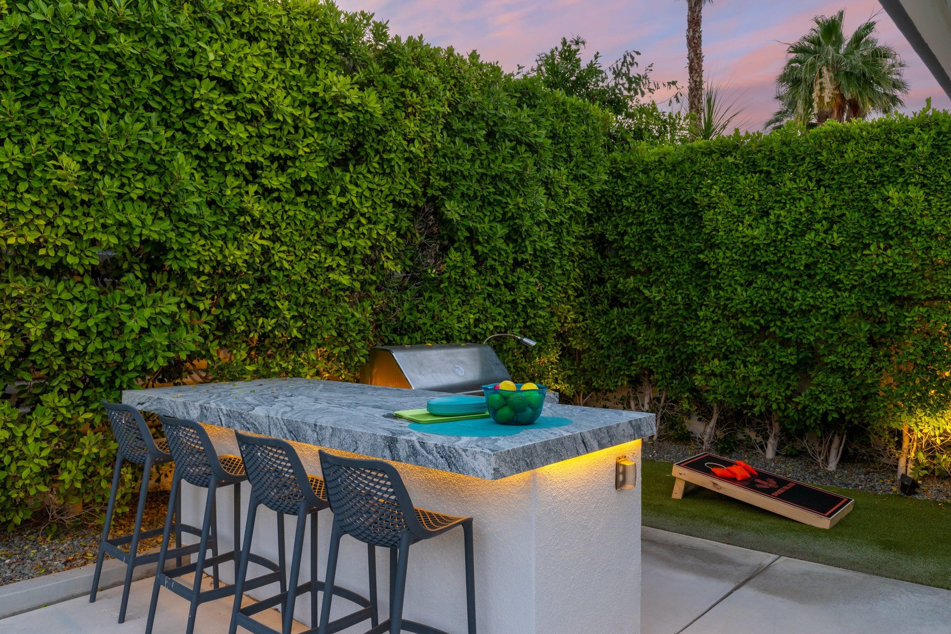 Additional shots of the beautiful BBQ grill, bar seating, and corn hole.