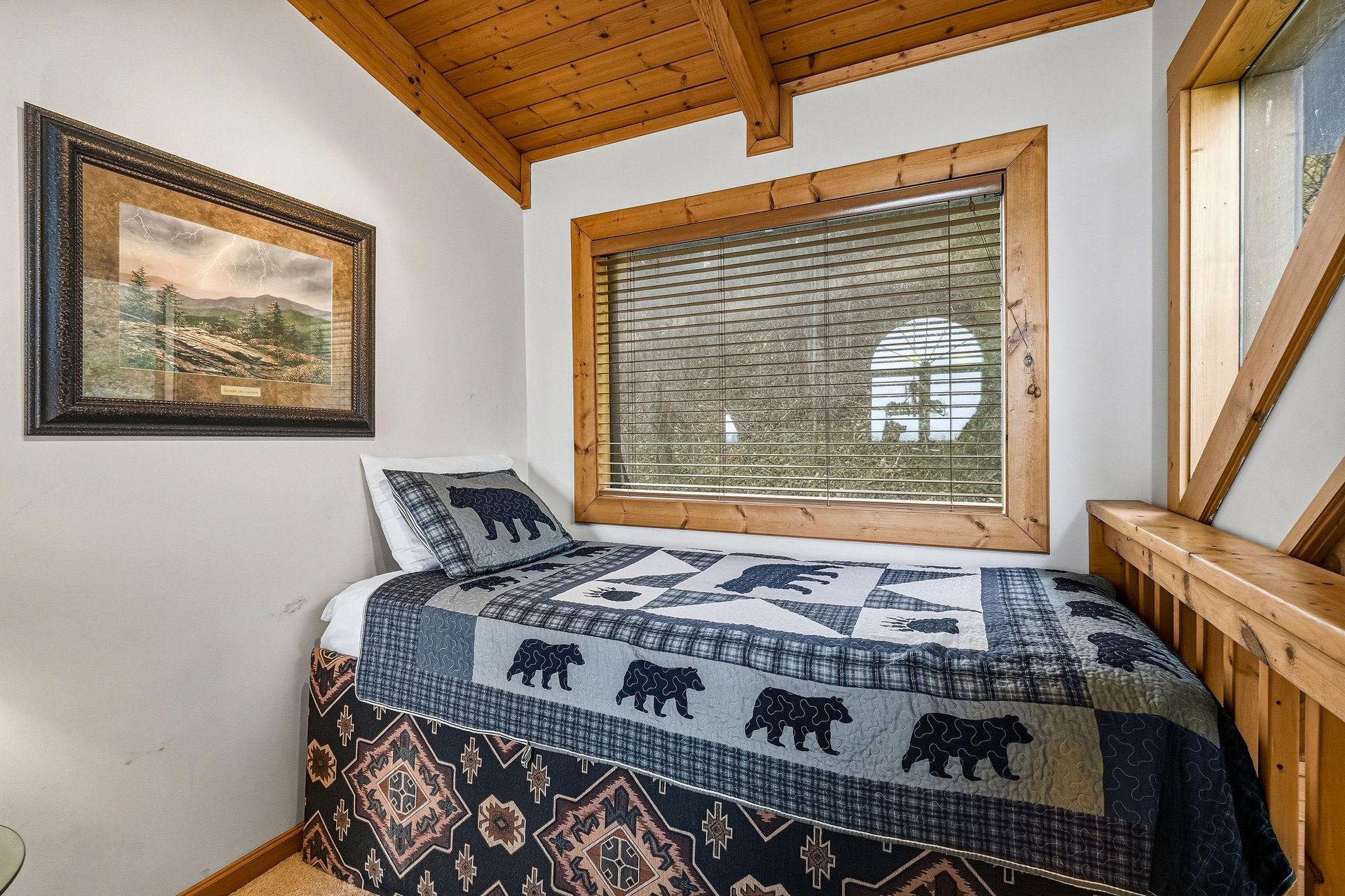 Cozy up in this charming bedroom featuring rustic wood beams and bearthemed bedding that perfectly captures your mountain getaway vibes.