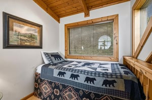 Cozy up in this charming bedroom featuring rustic wood beams and bearthemed bedding that perfectly captures your mountain getaway vibes.