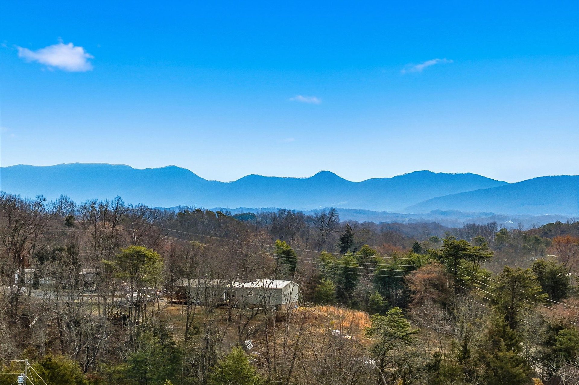 Stunning mountain vistas stretch across layered blue ridges under brilliant skies, creating a peaceful backdrop for your countryside getaway.