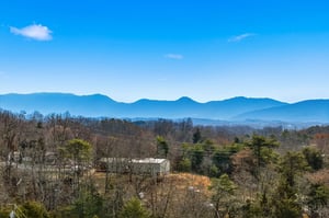 Stunning mountain vistas stretch across layered blue ridges under brilliant skies, creating a peaceful backdrop for your countryside getaway.