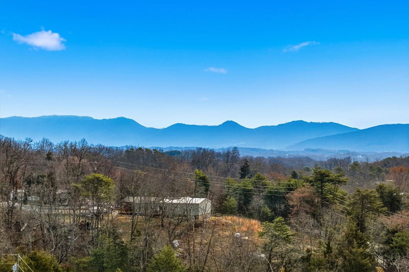 Stunning mountain vistas stretch across layered blue ridges under brilliant skies, creating a peaceful backdrop for your countryside getaway.
