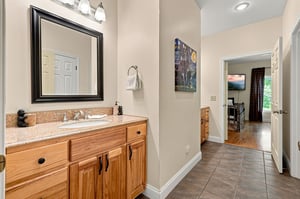 Freshen up in your private bathroom featuring natural wood cabinetry, a granite countertop, and plenty of space to spread out before exploring the days adventures.