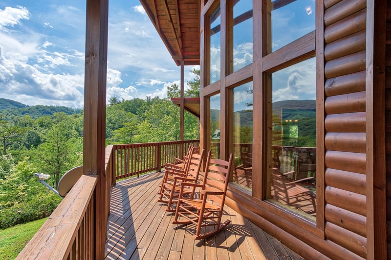 Rocking chairs on the covered deck overlooking the mountains at Four Seasons Lodge, a 3bedroom cabin rental located in Pigeon Forge