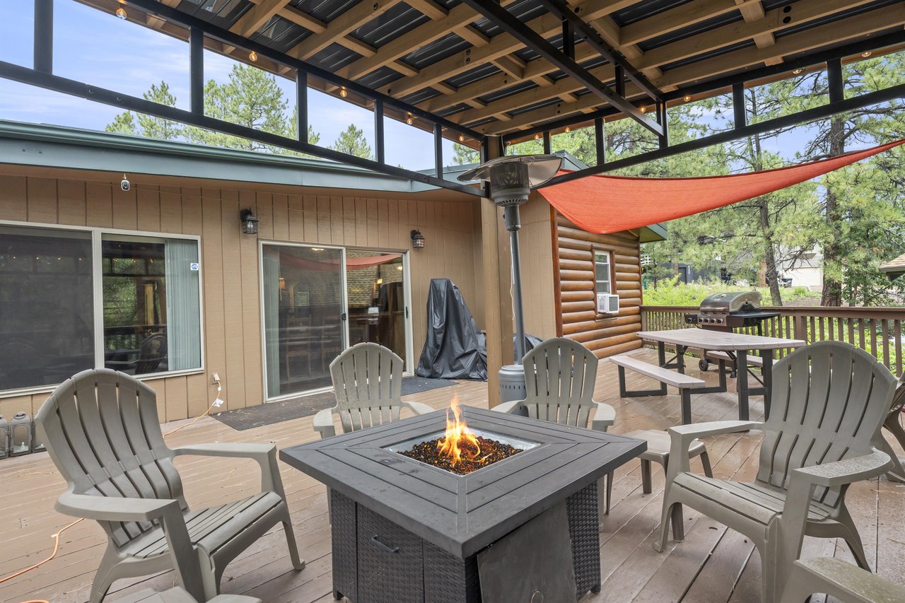 Back deck with covered firepit area, sun sails, BBQ, and outdoor games.