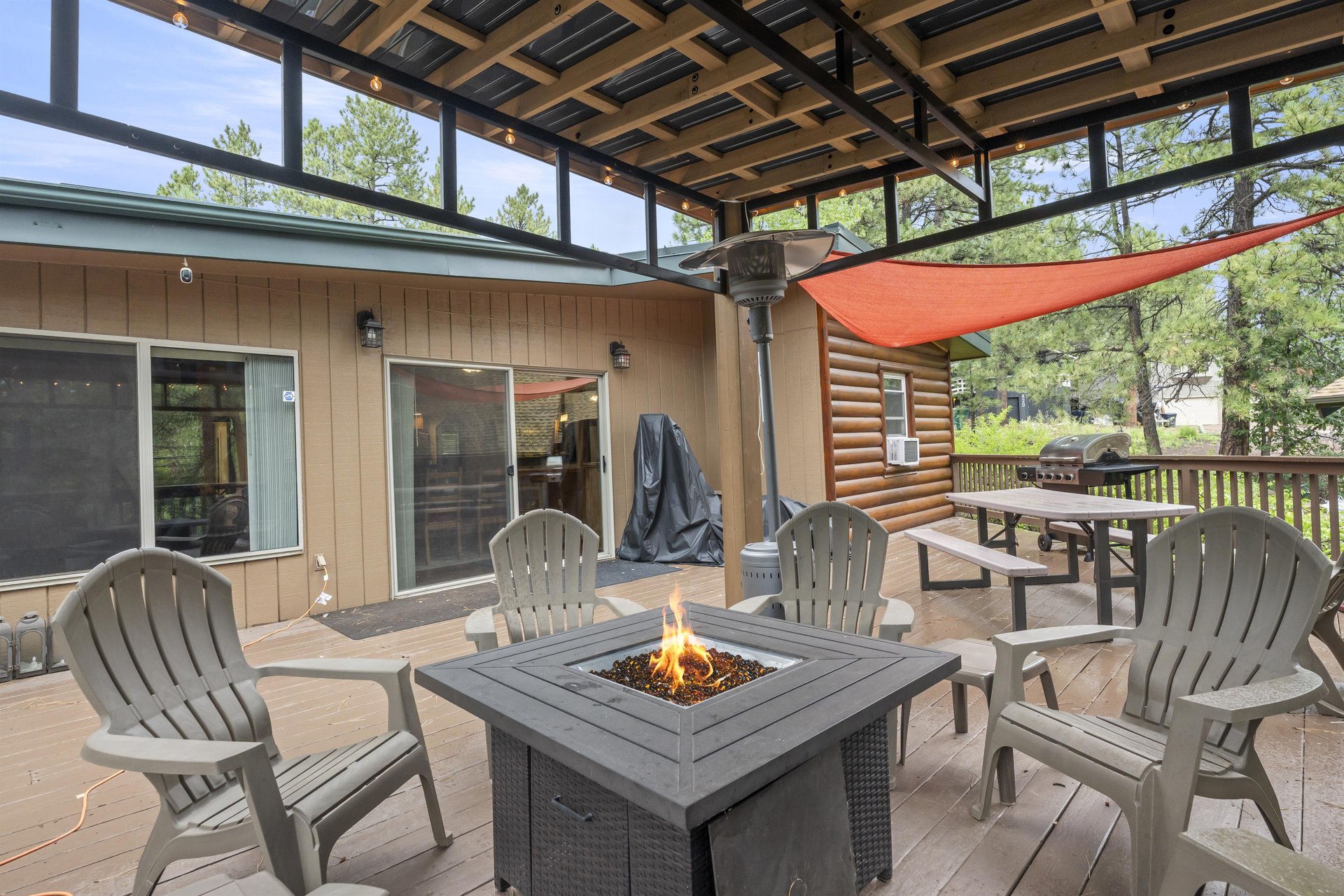 Back deck with covered firepit area, sun sails, BBQ, and outdoor games.