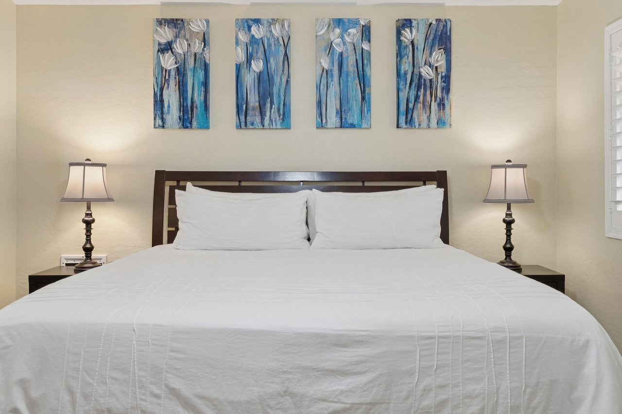 Main bedroom features a plush king bed
