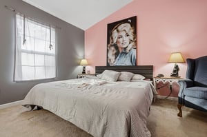 Sink into soft linens and wake up to natural light in your stylish bedroom, complete with cozy seating for morning coffee.