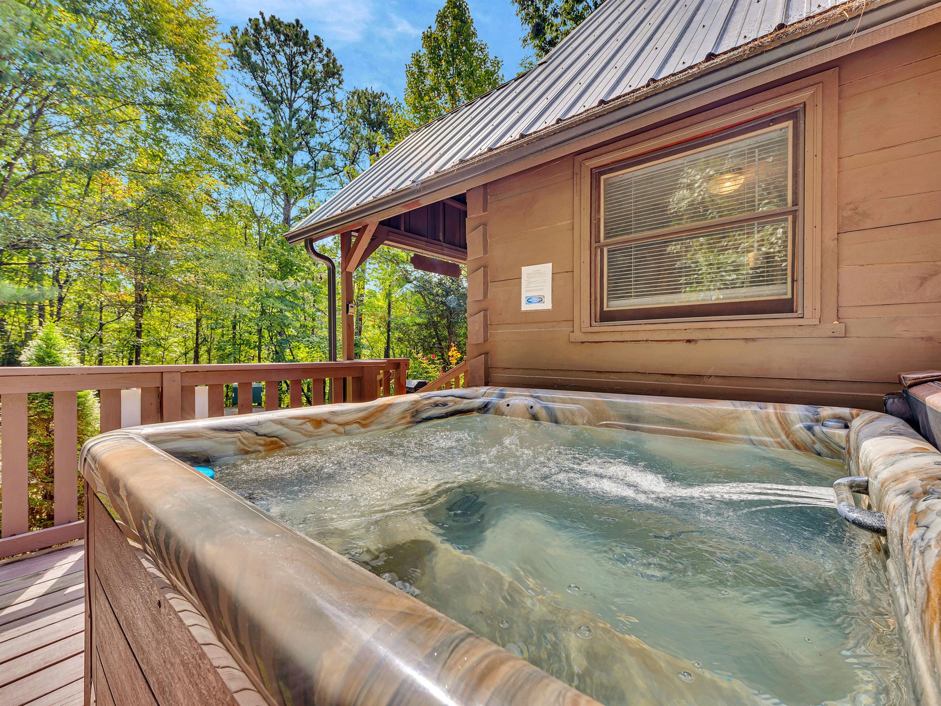 Slip into your private hot tub surrounded by towering trees, where warm bubbles and forest views create your perfect mountain retreat.