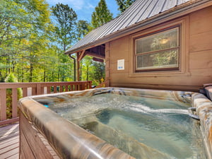 Slip into your private hot tub surrounded by towering trees, where warm bubbles and forest views create your perfect mountain retreat.