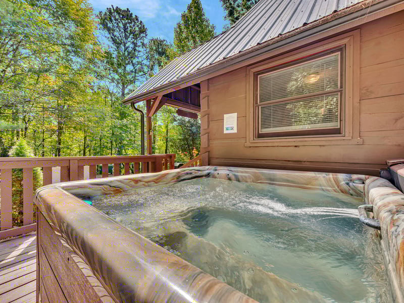 Slip into your private hot tub surrounded by towering trees, where warm bubbles and forest views create your perfect mountain retreat.