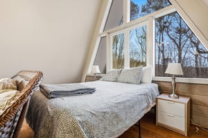 Wake up in your cozy loft bedroom with floortoceiling windows framing peaceful treetops. Natural light floods your restful retreat.
